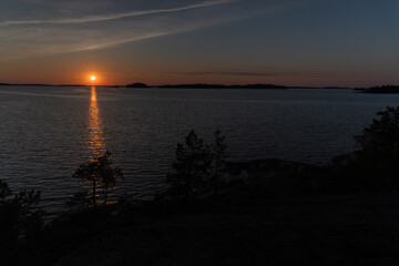 Sunset on the sea, rocks and northern low pines. Finnish nature. Turku. Vacation, vacation, relaxation concept