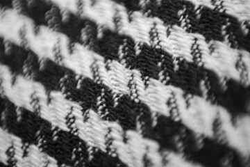 Woolen fabric in black and white check with a Pepita pattern. Macrophoto.
