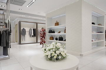 Modern interior of a women's clothing store in pastel and white colors.