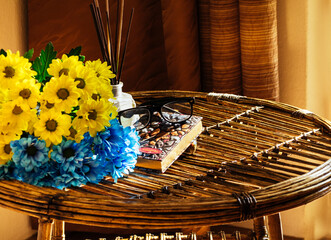 żółto-niebieskie jasne kwiaty na słomianym stole na wsi w ciepłych promieniach jesiennego...