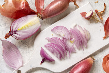 Sliced Red tropea onions on a white board top view - obrazy, fototapety, plakaty