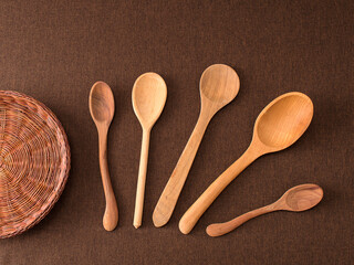 wooden spoons on brown background.