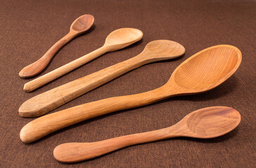 wooden spoons on brown background.