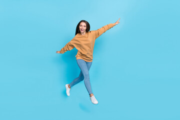 Obraz premium Full body photo of cute millennial brunette lady run wear sweater jeans footwear isolated on blue background