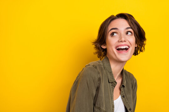 Photo of young cheerful woman laughing humorous look empty space ads isolated over yellow color background
