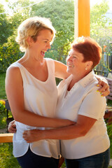 An adult daughter and an elderly mother in nature or in the village resting together. The concept of a loving family