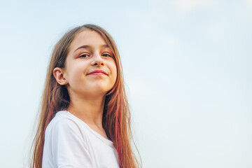 Portrait of a teenage girl with long hair against the sky. Girl 11 years old.