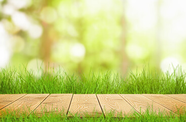 wooden table top and spring grass on defocus natural background