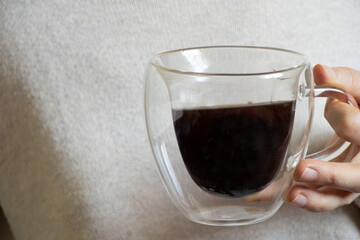 a cup of coffee in the hands of a girl, the girl drinks coffee in the morning for breakfast, coffee