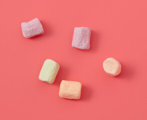 Multicolored candies on a pink background. Close-up