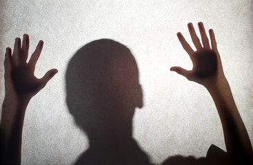 Illustration of a spooky silhouette of a man watching from afar, with white eyes and raised hands