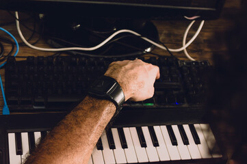 man using computer keyboard producing music in his home studio