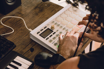 rear view of man making beat on midi controller in his home studio