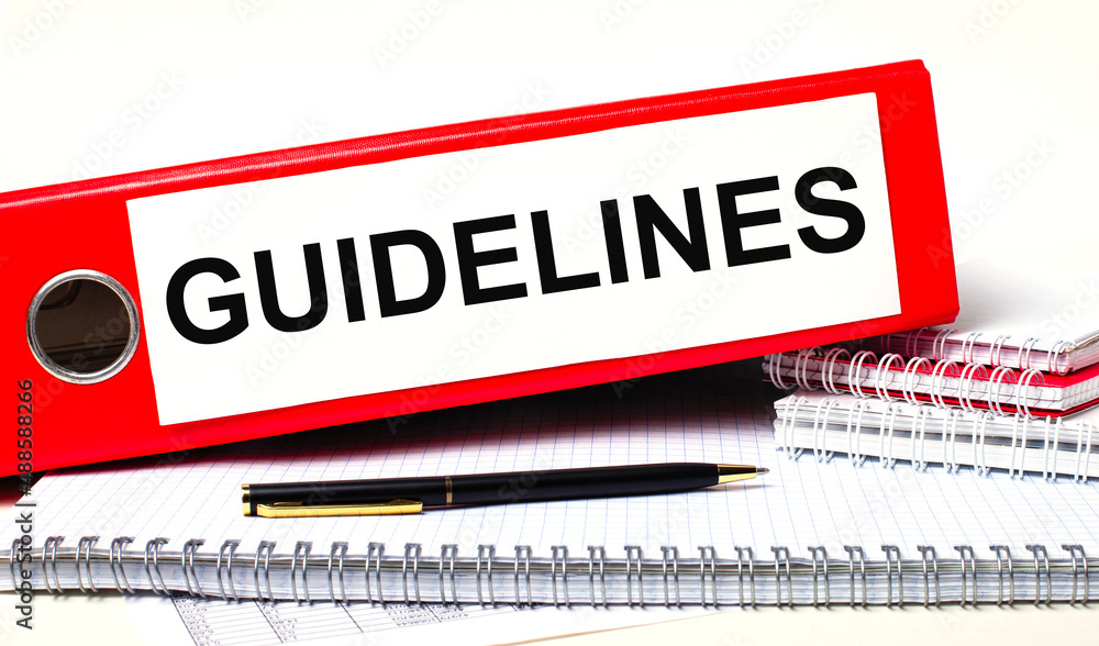 Poster on the desktop are notebooks, a pen and a red folder for papers with the text guidelines. business c