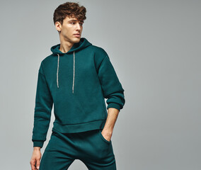 Handsome man wear of green set of track suit isolated on gray background - 488589645