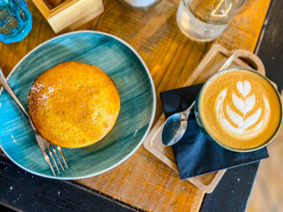 Pancake con sciroppo d'acero e cappuccino serviti per colazione in un bistrot e fotografati dall'alto