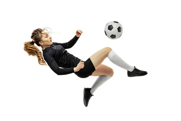 Leg kick. One sportive girl, female soccer player training with football ball isolated on white...