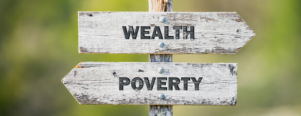 opposite signs on wooden signpost with the text quote wealth poverty engraved. Web banner format.