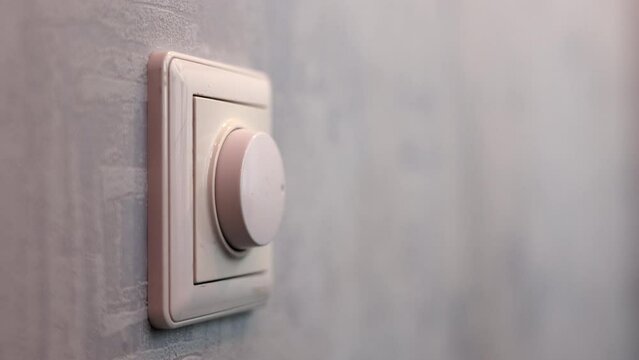Male Hand Close-up Turns The Dimmer Switch On The Light Switch