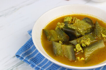 Kari Terong or Eggplant Curry, Asian food made from eggplant, curry spices, and coconut milk. Served on white bowl on isolated background. 