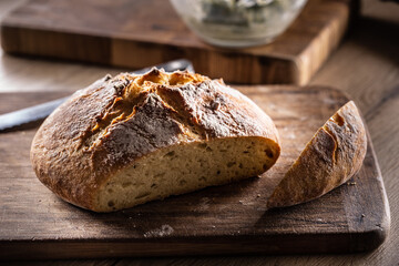 Freshly baked crusty bread with its first slice cut off
