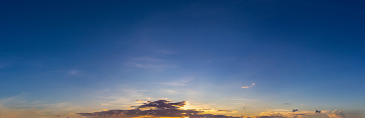 Panorama photo of clouds or cloudscape with dark blue sky at sunset or evening time.