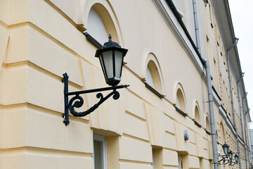Fototapeta na wymiar Lighting lantern on the wall of an old building. Old urban architecture of one of the streets of Moscow.