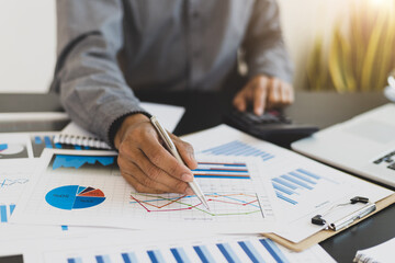 Businessman pointing to business white paper and analyzing planning.