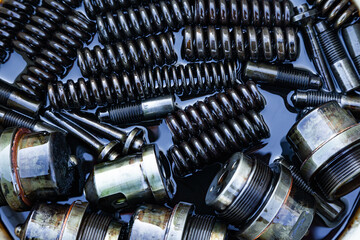 Steel mechanical parts lubricated with machine oil, close-up. Steel injectors, springs, bushings,...