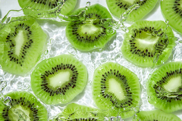 Kiwi slices in water on a white background. Peeled and sliced kiwi.