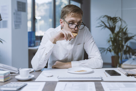 Sad office worker eating a very small meal