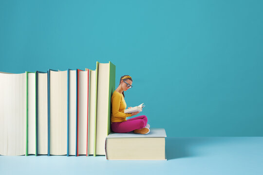 Tiny woman reading books and learning