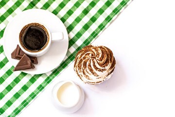 Dark chocolate and cocoa chocolate cupcakes with a cup of hot black coffee on green napkin. Space for text