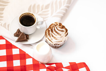 Dark chocolate and cocoa chocolate cupcakes with a cup of hot black coffee on red napkin. Space for text