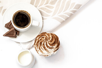 Dark chocolate and cocoa chocolate cupcakes with a cup of hot black coffee on green napkin. Space for text