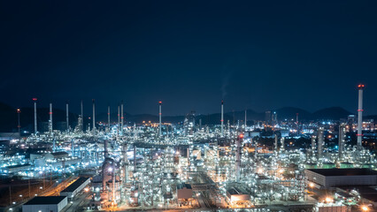 Oil and gas refinery plant or petrochemical industry at night sky, Manufacturing of petroleum industrial business aerial view photograph from drone