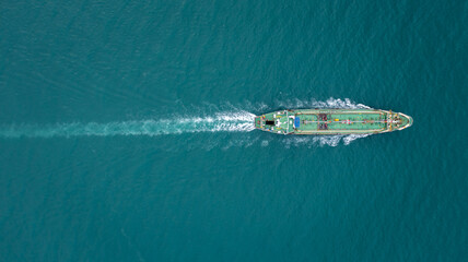 Aerial top view Oil ship tanker sailing full speed with beautiful wave and splash water in line of...