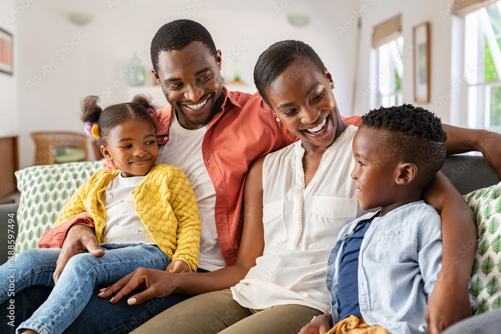 Wall mural Happy black family playing together at home