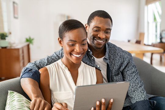 Happy mature african american couple using digital tablet at home