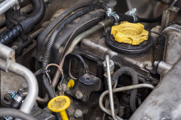 Yellow cap on diesel engine with traces of oil.
