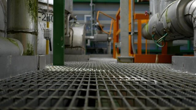 Built inside a steel structure oil and chemical refinery consisting of pipes, valves, controls devise and machine. Panning video