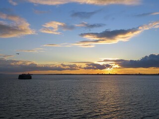 beautiful orange sunset over the sea with blue sky and wispy cloud formations