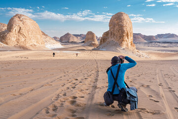 Unrecognizable man taking photo of white desert
