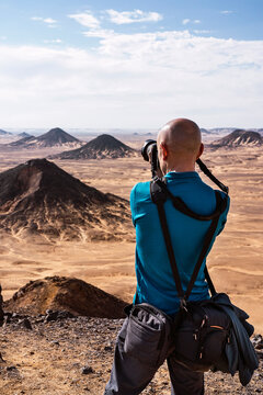 Anonymous man taking photo of black desert