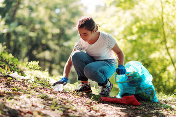 Girl cleaning up the forest and collecting trash