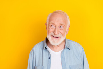 Portrait of attractive bewildered cheerful grey-haired man creating solution copy space isolated over bright yellow color background