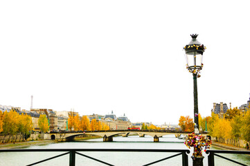 Paris in autumn.  Love locks bunch attached to streetlamp. View of Eiffel tower, bridges and golden trees at embankment park.