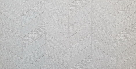 Close-up of an interior wall in a building with white chevron wallpaper installed. Plaster wall seamless texture with chevron pattern
