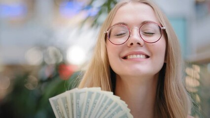 Happy wealthy successful girl cheerful businesswoman looking at camera female rich lifestyle hiding behind dollar banknotes spending money showing financial profit lady winning salary save loan credit