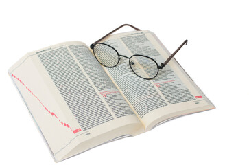 Glasses lying on the Bible in Polish isolated on a white background